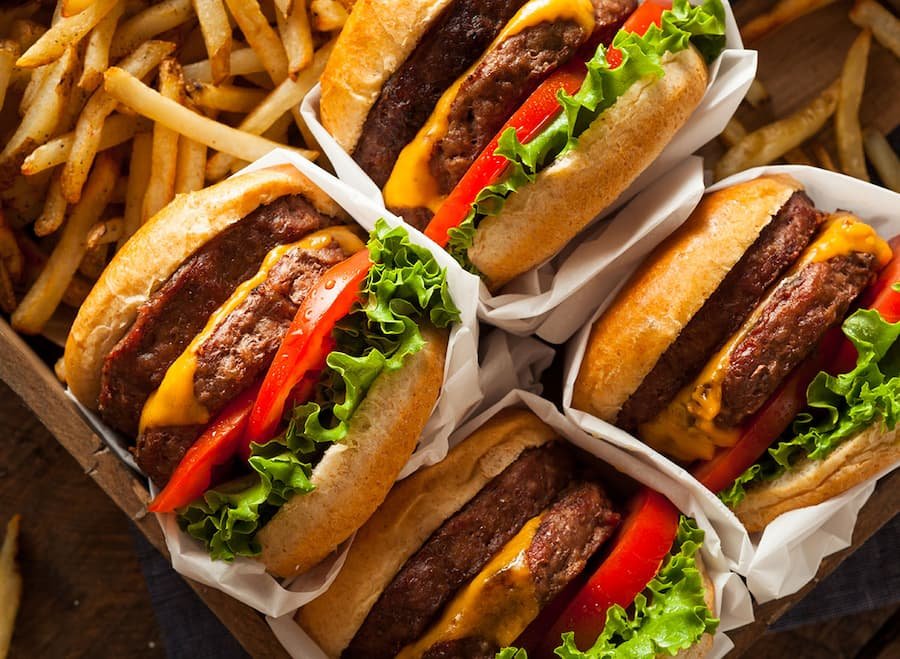 Four beef burgers showcasing fast food cravings
