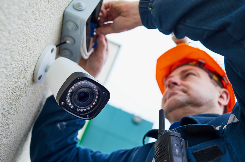 Man installing CCTV to enhance security system